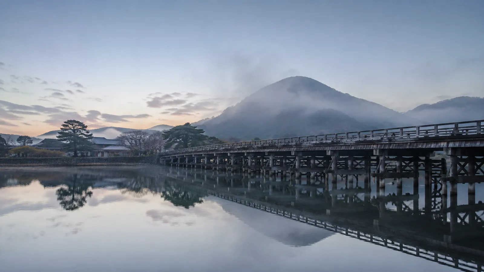 夜明けの大河にかかる古い木橋と霧の山 ── 和の情景（イメージ）